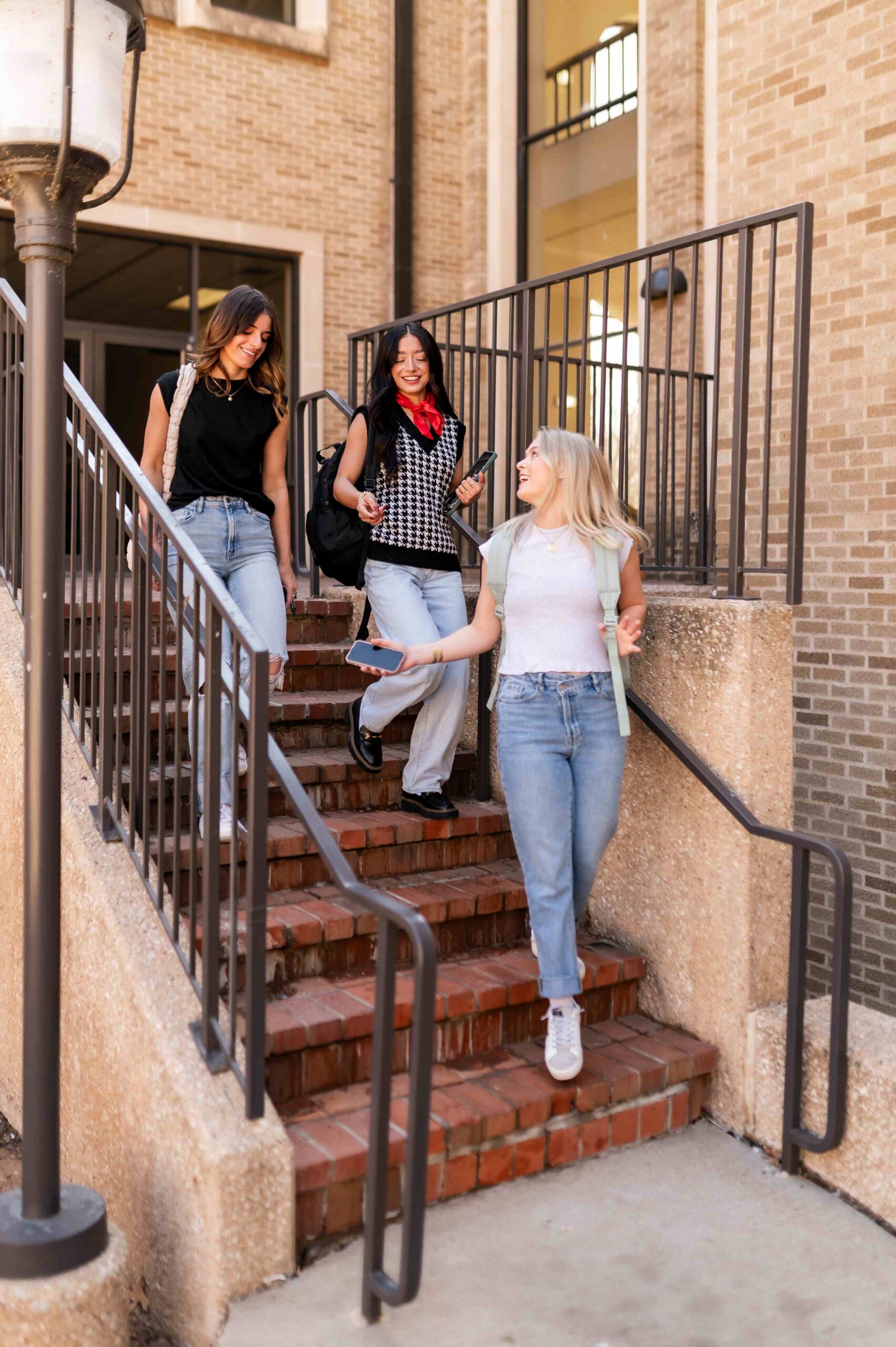 three students walking down stairs at troubadour in lubbock tx scaled