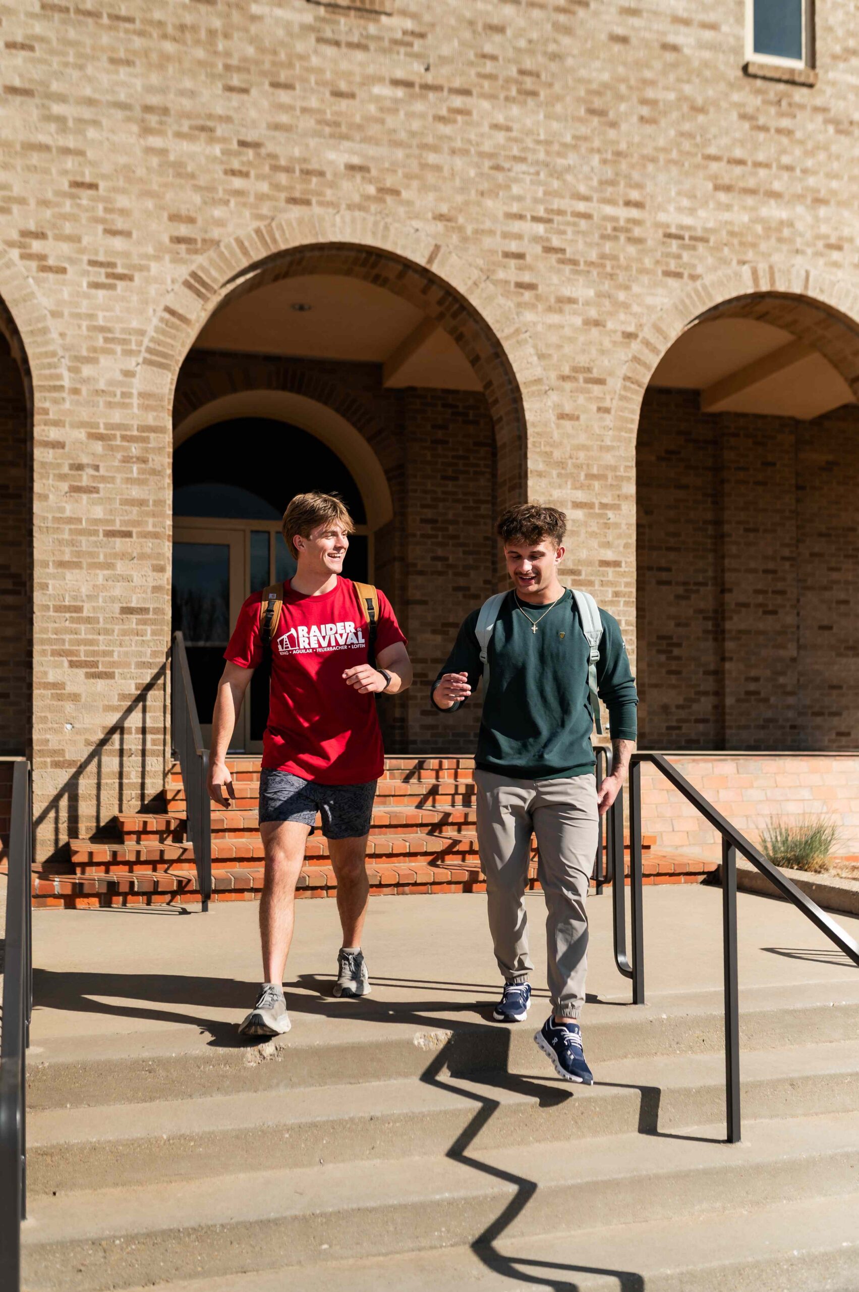 two students walking on campus near troubadour in lubbock tx scaled