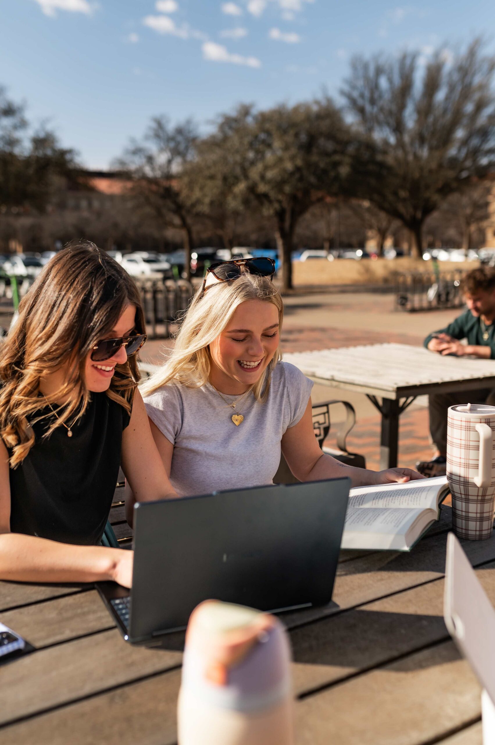 two women studying outdoors at troubadour in lubbock tx scaled